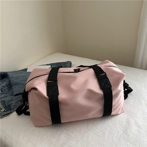 Pink large capacity travel duffel bag with black straps on white textured background
