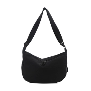 Minimalist black nylon dumpling bag with adjustable shoulder strap and side label