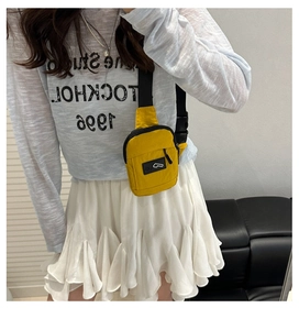 Fashionable yellow waterproof nylon chest bag with black strap shown on a model