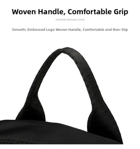 Detail of a durable woven handle on a black nylon backpack with a focus on fabric texture