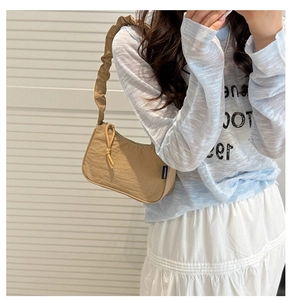 Detail of khaki pleated hobo bag with ruffled strap and vintage crescent design