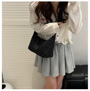 Model wearing black crescent nylon crossbody bag with adjustable strap for casual daily use