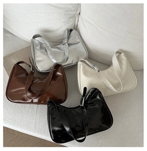Flat lay of high-gloss hobo bags in silver, brown, cream, and black colors