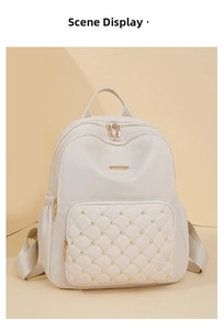 Detail of beige nylon backpack with quilted diamond patterns and gold rivet accents