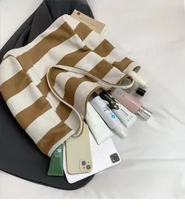 Top-down detail of striped canvas tote bag showing large capacity for tablet and items