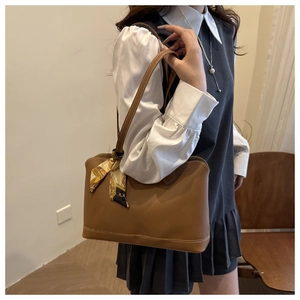 Brown leather tote bag featuring a vintage printed silk scarf on the handle for styling