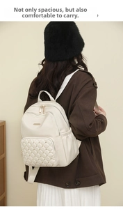 Detail of beige nylon backpack with diamond quilting, gold rivets and side pockets