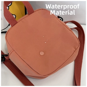 Détail du tissu imperméable du sac à bandoulière en toile rose avec des gouttes d'eau
