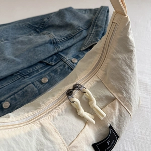 Minimalist beige dumpling canvas bag with double zipper and knot charm for women