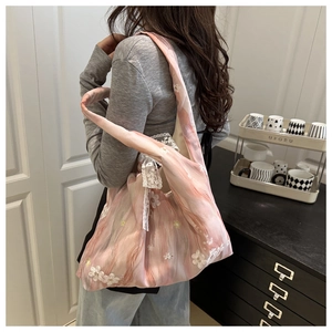 Detail of pink floral lace tote bag with white flower embroidery and mesh fabric