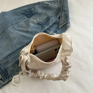 Chic cream nylon scrunchie handle shoulder bag showing interior storage for essentials