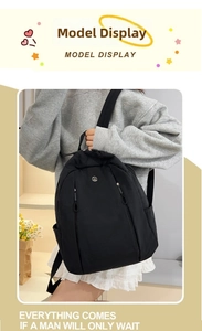 Detail view of lightweight black nylon backpack showing vertical zipper and side pocket