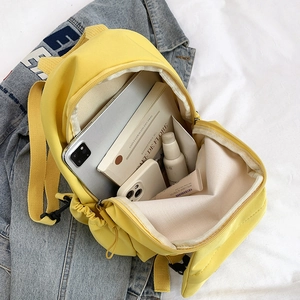 Waterproof yellow crossbody backpack interior showing tablet, books and daily items