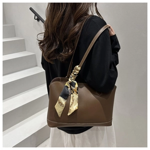 Detail of dark brown tote bag featuring reinforced stitching and silk scarf wrap handle