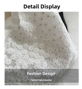 Close-up of intricate white lace embroidery with delicate floral patterns and mesh detail