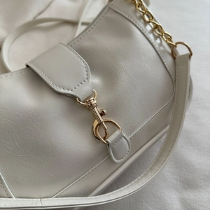Minimalist creamy white pleated leather shoulder bag with elegant gold chain strap and clasp