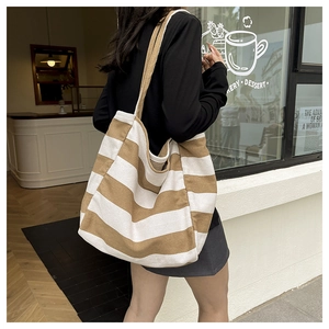 Macro detail of the brown and white striped canvas tote bag fabric and wide strap