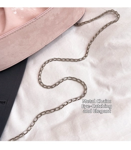 Gros plan d'un sac à bandoulière rose plissé avec chaîne dorée et logo en forme de cœur