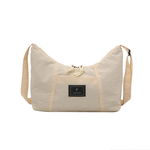 Minimalist beige nylon crescent crossbody bag with adjustable strap and front logo patch