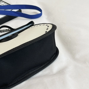Minimalist black and white canvas crossbody bag with metal chain strap and top stitching