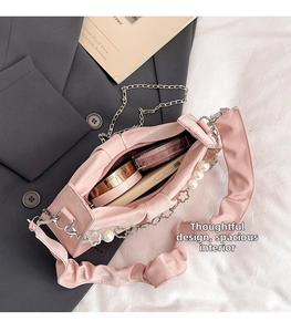 Détail de l'intérieur du sac plissé rose montrant une grande capacité pour le maquillage