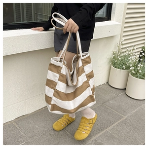 Brown and beige striped canvas tote bag showing large capacity and soft fabric texture