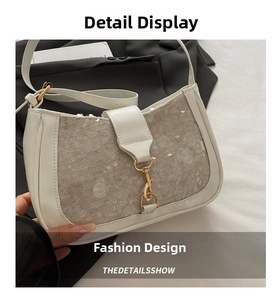 Detailed view of white leather underarm bag with silver sequins and gold metal clasp