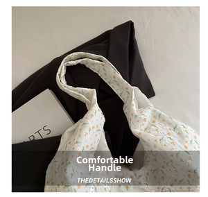 Detail of white canvas tote bag with yellow floral print and elegant white embroidery
