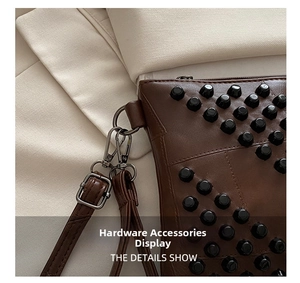 Detail shot of brown leather bag with black metal rivets and silver twist lock hardware