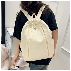 Rear view of model wearing an off-white lightweight nylon backpack with side pockets