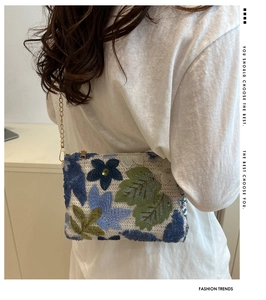 Back view of a model wearing a sequined floral embroidery bag with a metal chain strap