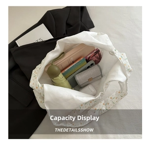 Detailed top view of large capacity white floral tote bag with items for daily commute