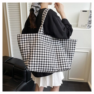 Photo de mannequin d'un sac cabas en toile à damier noir et blanc avec accessoire assorti