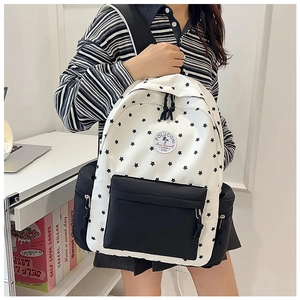 Close-up of student backpack featuring star patterns and brand patch on canvas material