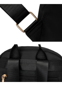 Detail of durable nylon fabric and shiny gold metal hardware on a black backpack