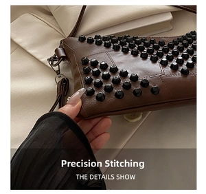 Detailed close-up of brown leather bag featuring black stud rivets and precise stitching