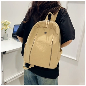 Detail view of khaki nylon backpack featuring smooth zippers and side pockets for commute