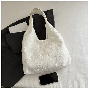 Close-up of white 3D floral embroidery on high-quality canvas tote bag material