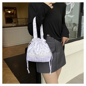 Close-up of floral lace bucket bag with drawstring closure and purple pattern