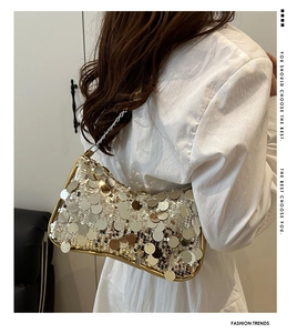 Detail of shimmering gold sequins on an underarm bag with a stylish metal chain