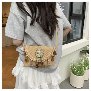 Detail of woven straw crossbody bag with colorful bohemian beads and tassel charms