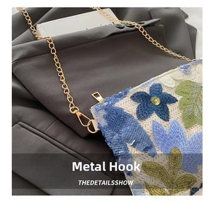 Close-up of gold chain strap hooks and floral embroidery on a Chinese-style bag