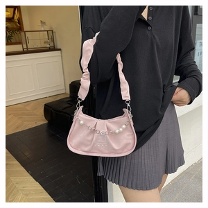 Détail du sac plissé rose avec chaîne en perles et métal et logo Amise & Good