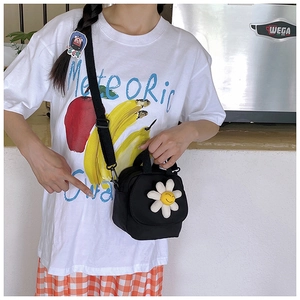 Détail d'un sac en toile noire avec broderie marguerite et bandoulière réglable
