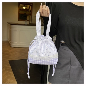 Detail of purple floral and gingham patchwork bag with white lace trim and drawstring