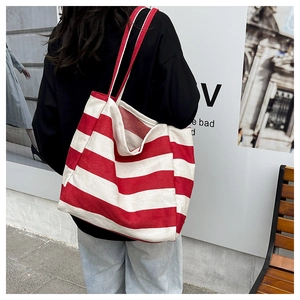 Outdoor shot showing the red and white striped canvas tote bag worn by a model