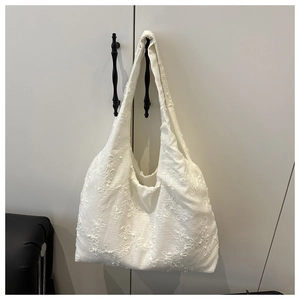 Detail of white ivory tote bag with delicate 3D floral embroidery and cotton fabric texture