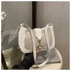 Close-up of white sequin shoulder bag with adjustable strap and metal hook detail