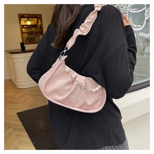 Vue détaillée du sac en satin rose froncé avec chaîne décorative en perles et fleurs