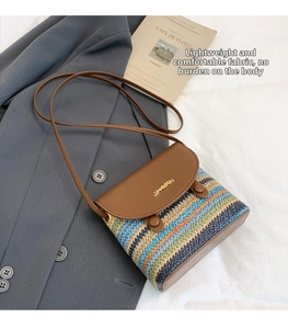 Detail of a retro rainbow woven crossbody bag with brown leather flap and gold metal logo
